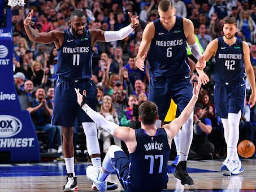 Doncic ayudado por sus compañeros en un partido de los Dallas Mavericks