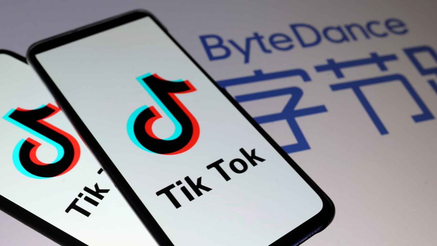 Logo de TikTok en un móvil con el de su matriz ByteDance de fondo.