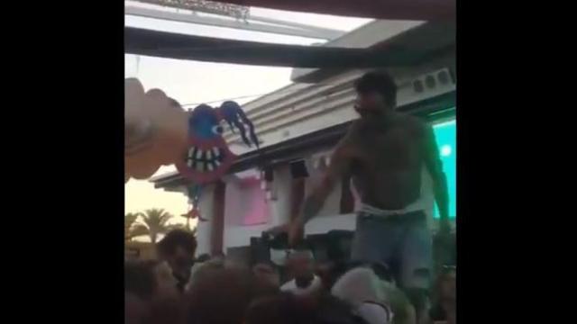 Fragmento del vídeo donde se ve al DJ dando alcohol de la misma botella a varios asistentes.