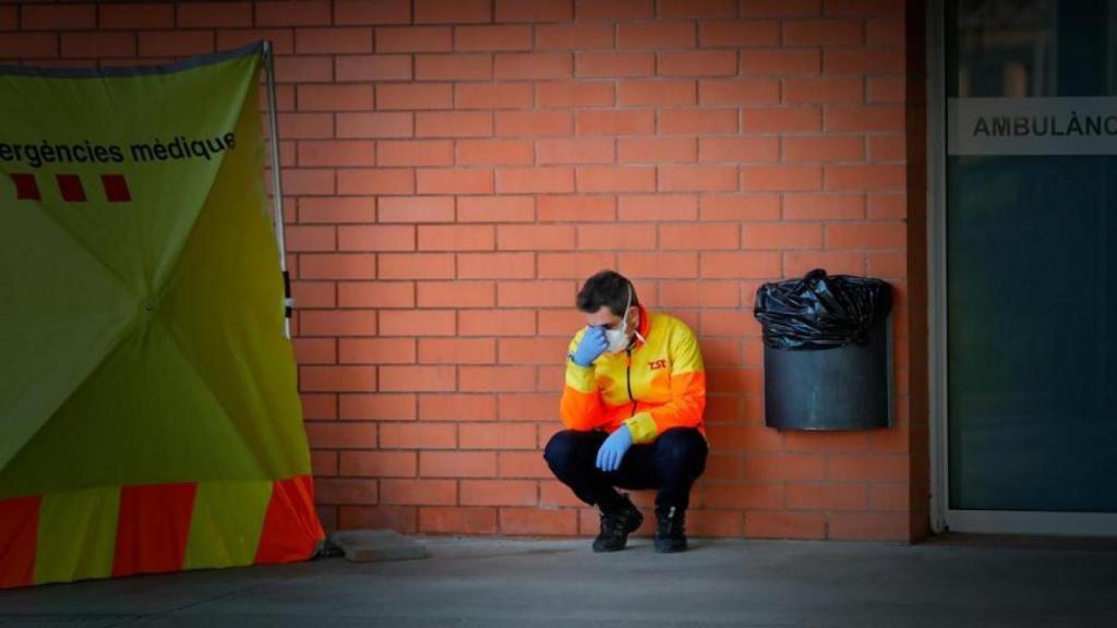 Un sanitario, exhausto, a las puertas de un hospital de campaña