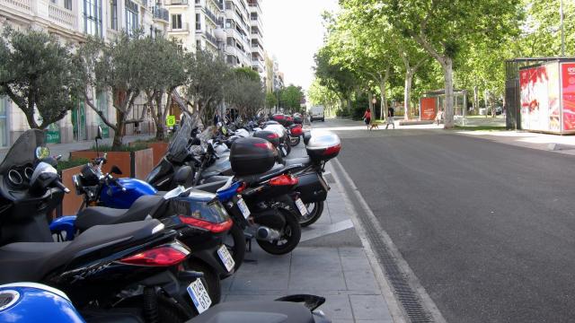 Varias motos aparcadas en la calle.