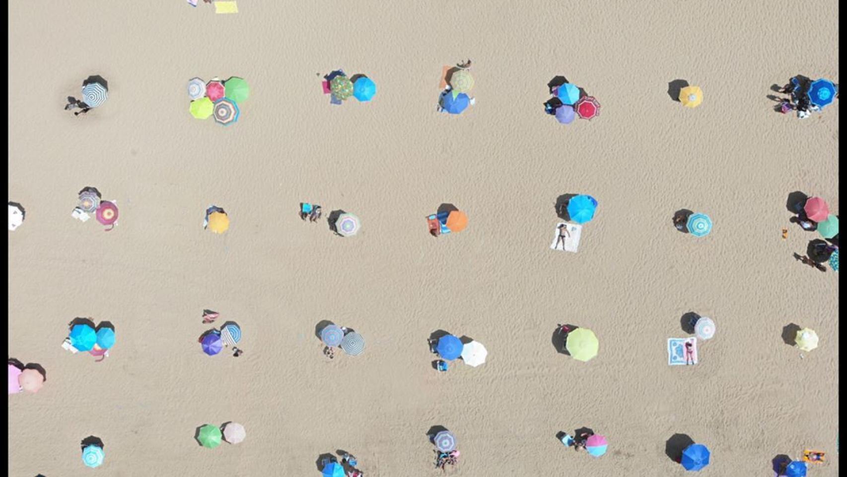 Imagen de una zona de playa de Punta Umbría con las sombrillas colocadas de forma simétrica.