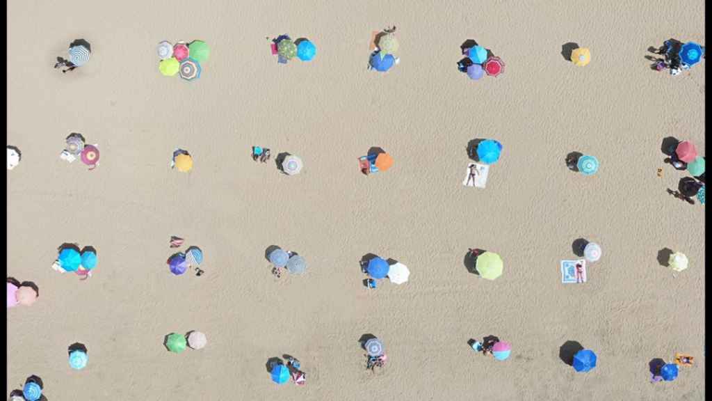 Imagen de una zona de playa de Punta Umbría con las sombrillas colocadas de forma simétrica.