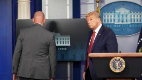 Un agente del Servicio Secreto saca a Donald Trump de la conferencia de prensa en la Casa Blanca.