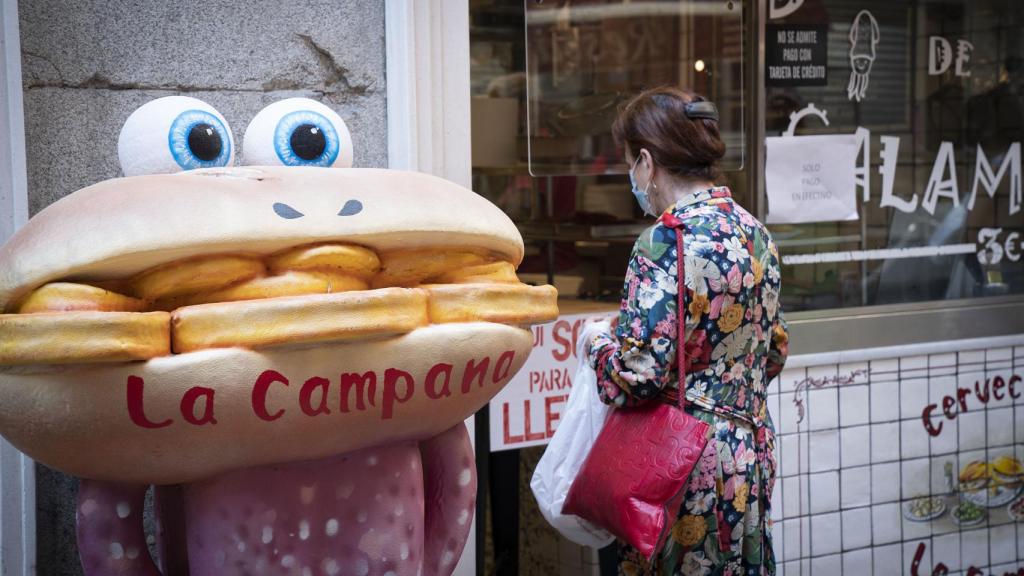 Una mujer espera a ser atendida en Bar La Campana, en Madrid.