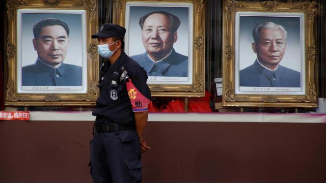 Un guardia de seguridad con mascarilla protectora en la calle peatonal Wangfujing en Beijing.