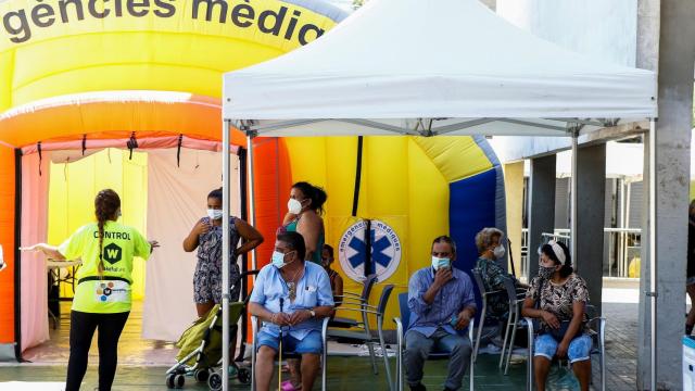 Ciudadanos del barrio del Besós de Barcelona guardan cola para ser sometidos a un cribado de coronavirus.