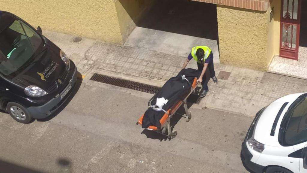 Un empleado de los servicios funerario sacando el cuerpo sin vida de Ana del bloque de pisos.