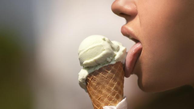 Una joven lamiendo un helado.