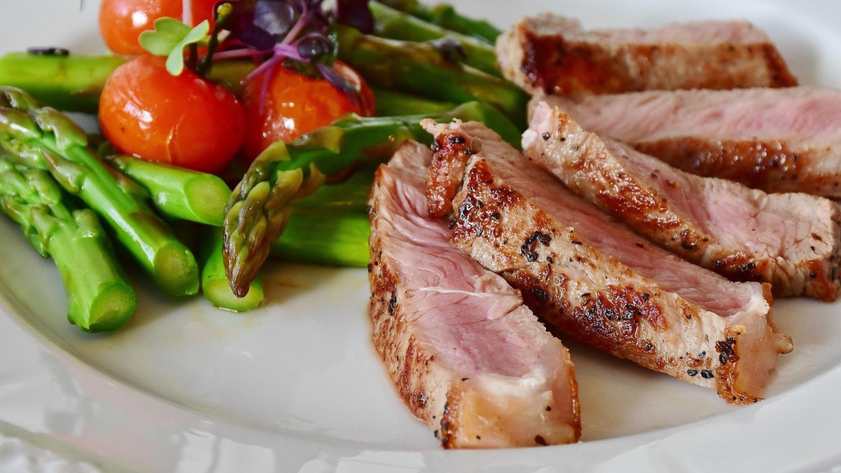 Una comida con proteína animal y verduras.