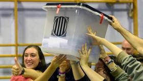 Un grupo de personas levanta una urna durante el referéndum del 1 de octubre de 2017 en Cataluña.