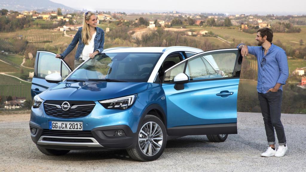 Una pareja junto a un coche nuevo.