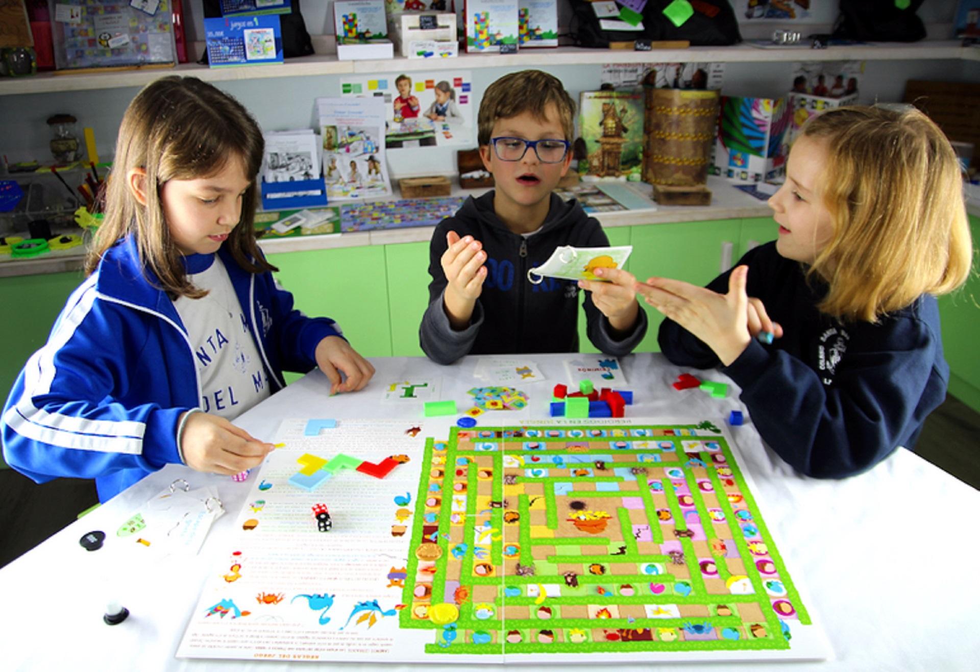 Dos niñas y un niño aprenden matemáticas con uno de los juegos de Crecer Creando.
