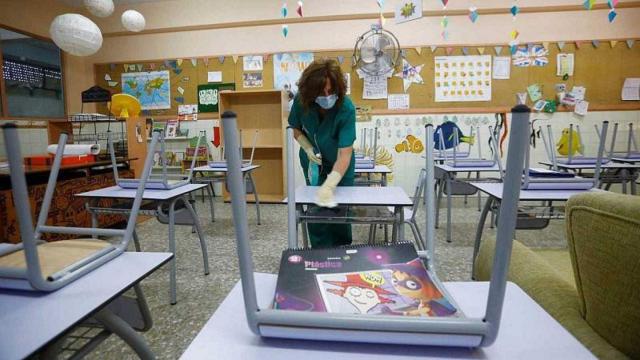 Limpian un colegio a la espera de que comiencen las clases.