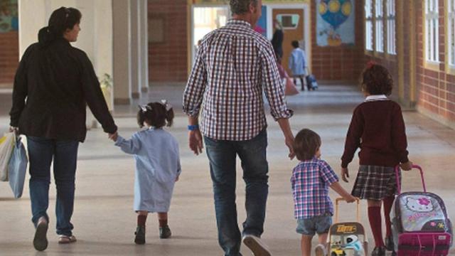 Los padres entran con sus hijos a clase.