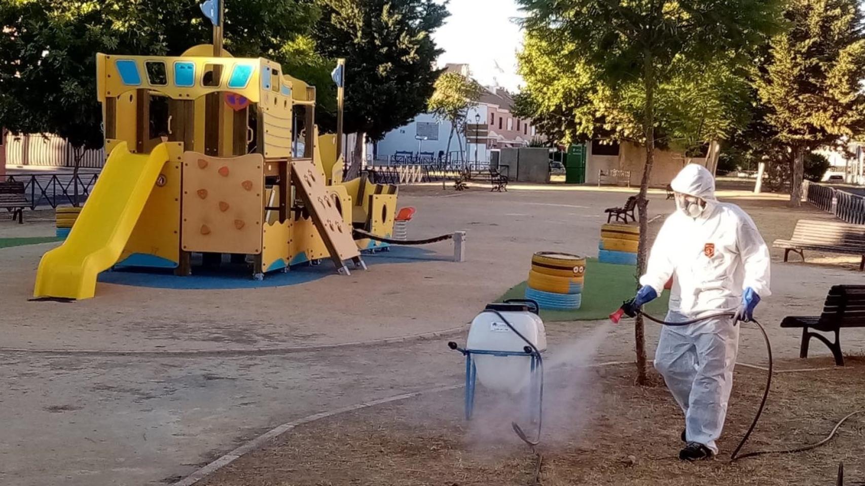 Un operario fumigando un parque infantil.