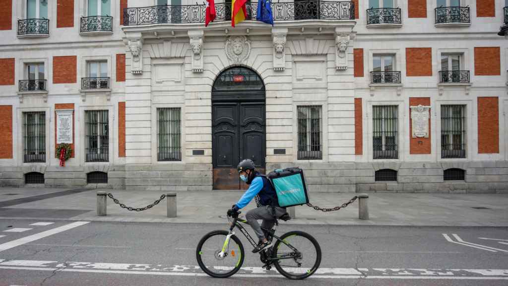 Un rider de Deliveroo circula por la Puerta del Sol de Madrid.
