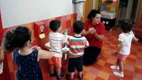 Una profesora explica a un grupo de menores cómo lavarse las manos.