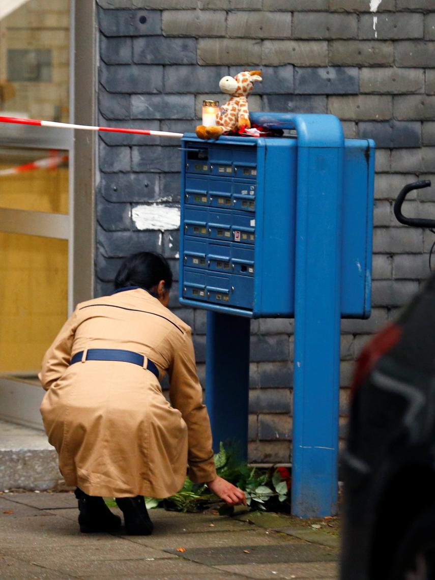 Una mujer deposita una rosa en el buzón del domicilio de los cincos niños asesinados.