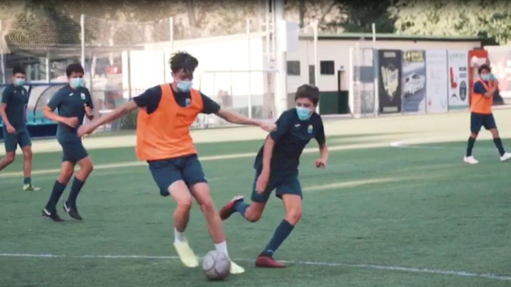 Jóvenes de un equipo de Madrid jugando al fútbol con mascarilla