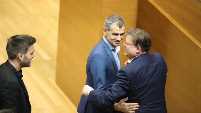 Abrazo entre Toni Cantó y Ximo Puig ante la mirada de Fran Ferri. EE