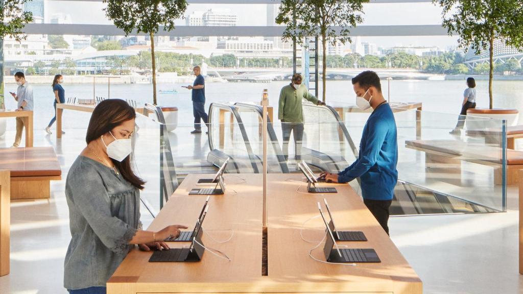 Una Apple Store con varios usuarios con mascarilla.