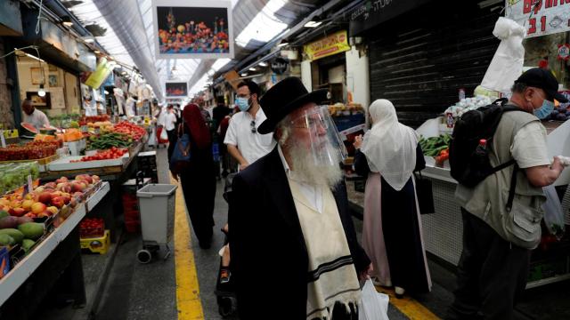 Personas con mascarillas o pantallas protectoras en el principal mercado de Jerusalén.