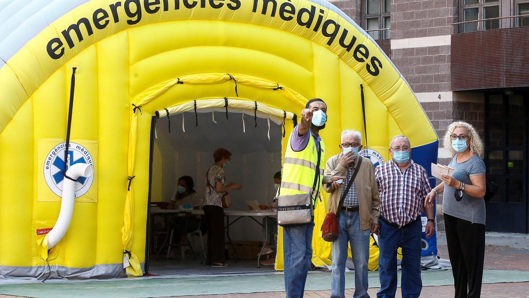 Varias personas acceden a la zona de realización de PCR durante el primer día de cribados masivos de Covid-19 en El Raval de Barcelona