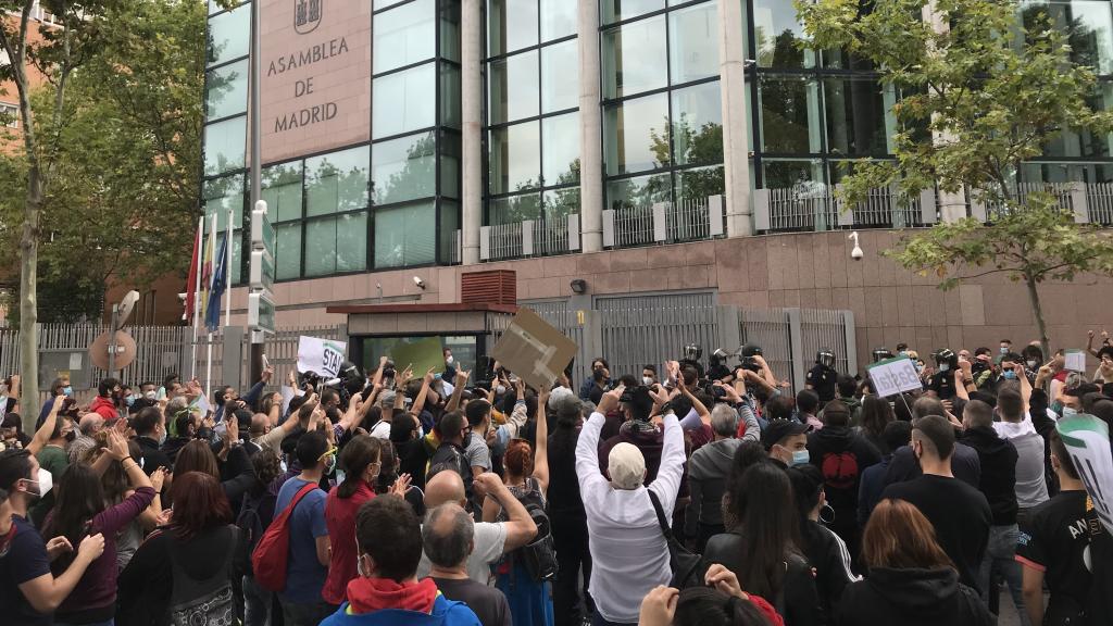 Manifestantes contra la Policía, a la entrada de la Asamblea de Madrid.