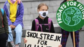 Greta Thunberg sostiene un cartel que dice  Huelga escolar por el clima frente al Parlamento sueco.
