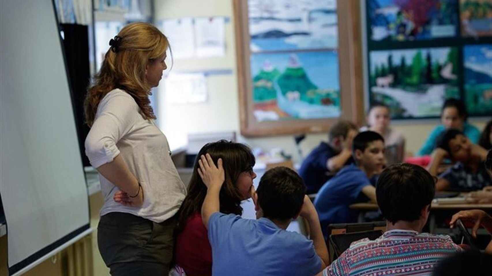 Una profesora da clase en un aula.