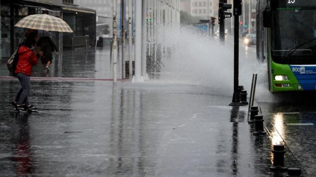 Un autobús urbano salpica al pasar por un charco este sábado en San Sebastián. EFE/Javier Etxezarreta