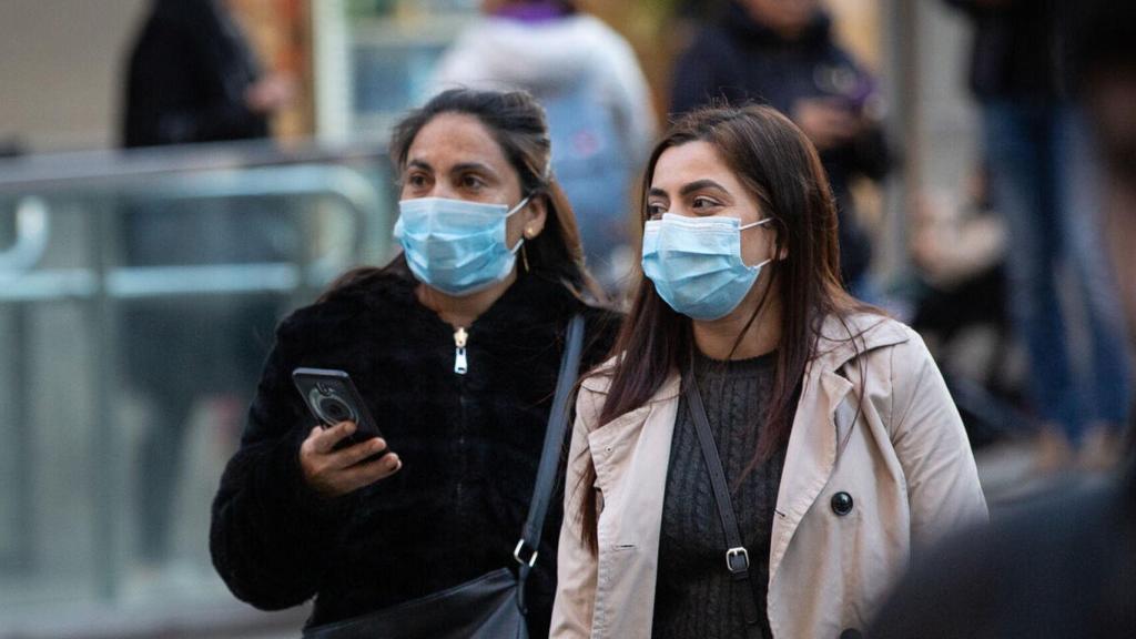 Dos mujeres pasean con mascarilla por el centro de Madrid