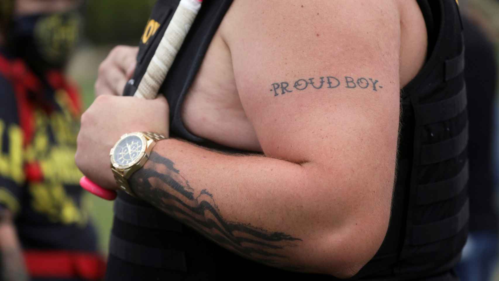 Un hombre luce un tatuaje con las palabras 'Proud Boys'.