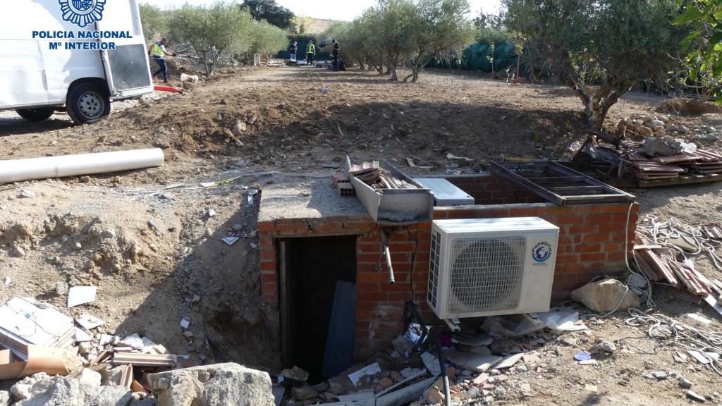 Los agentes de la policía caminando sobre el terreno donde se guardaba la droga.