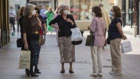 Un grupo de mujeres conversa en una calle de Sevilla con las mascarillas puestas.
