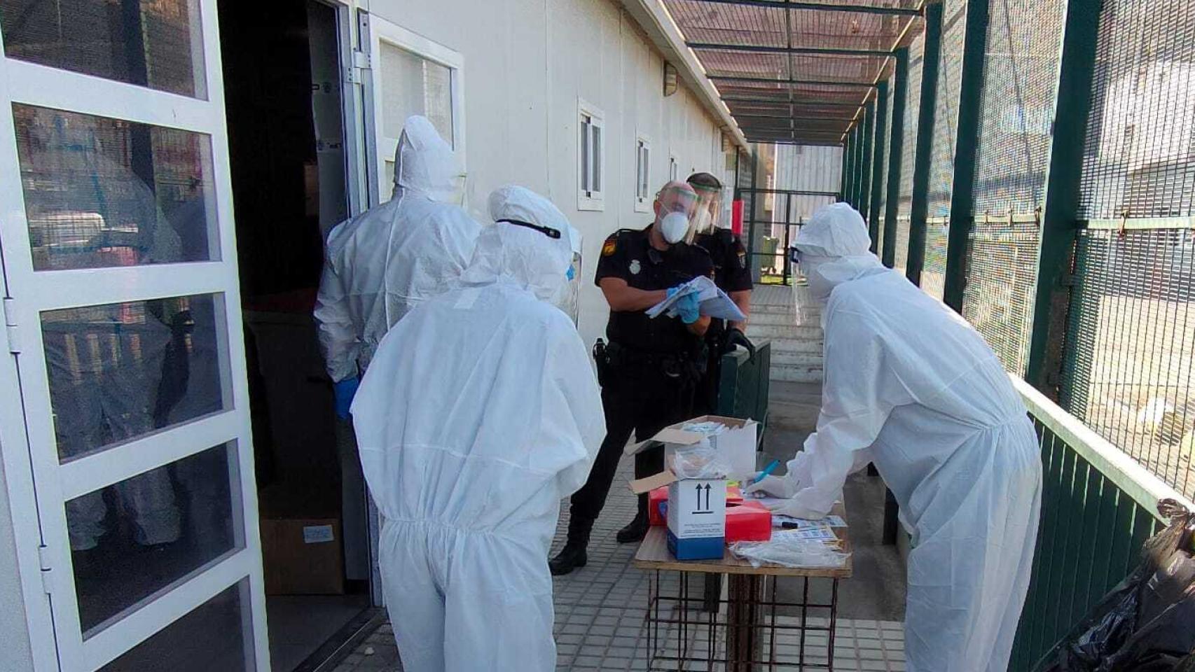 Policías y sanitarios en el CATE de Almería donde custodian a 161 'sin papeles'.