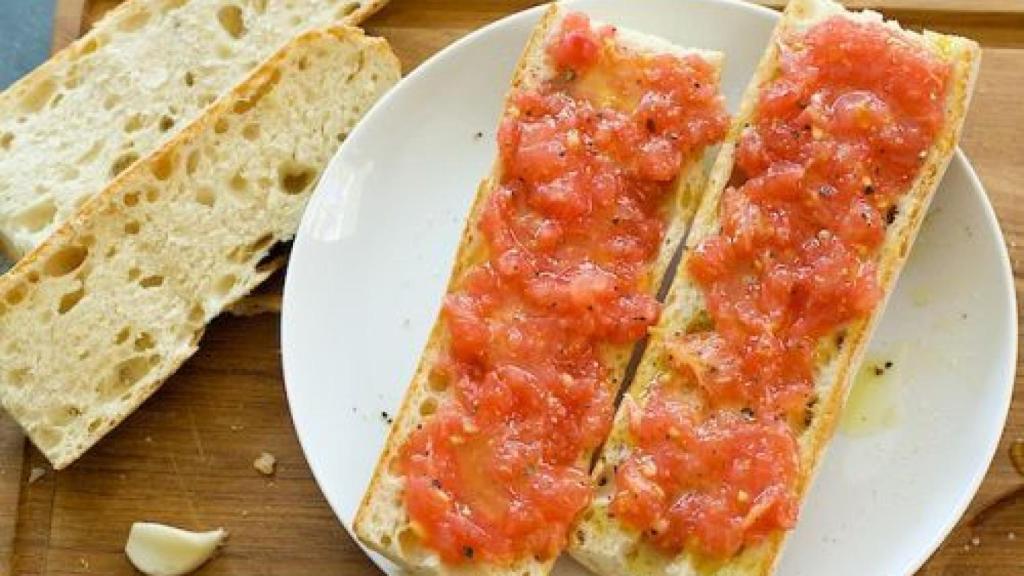 Dos rebanadas de pan con tomate rallado.