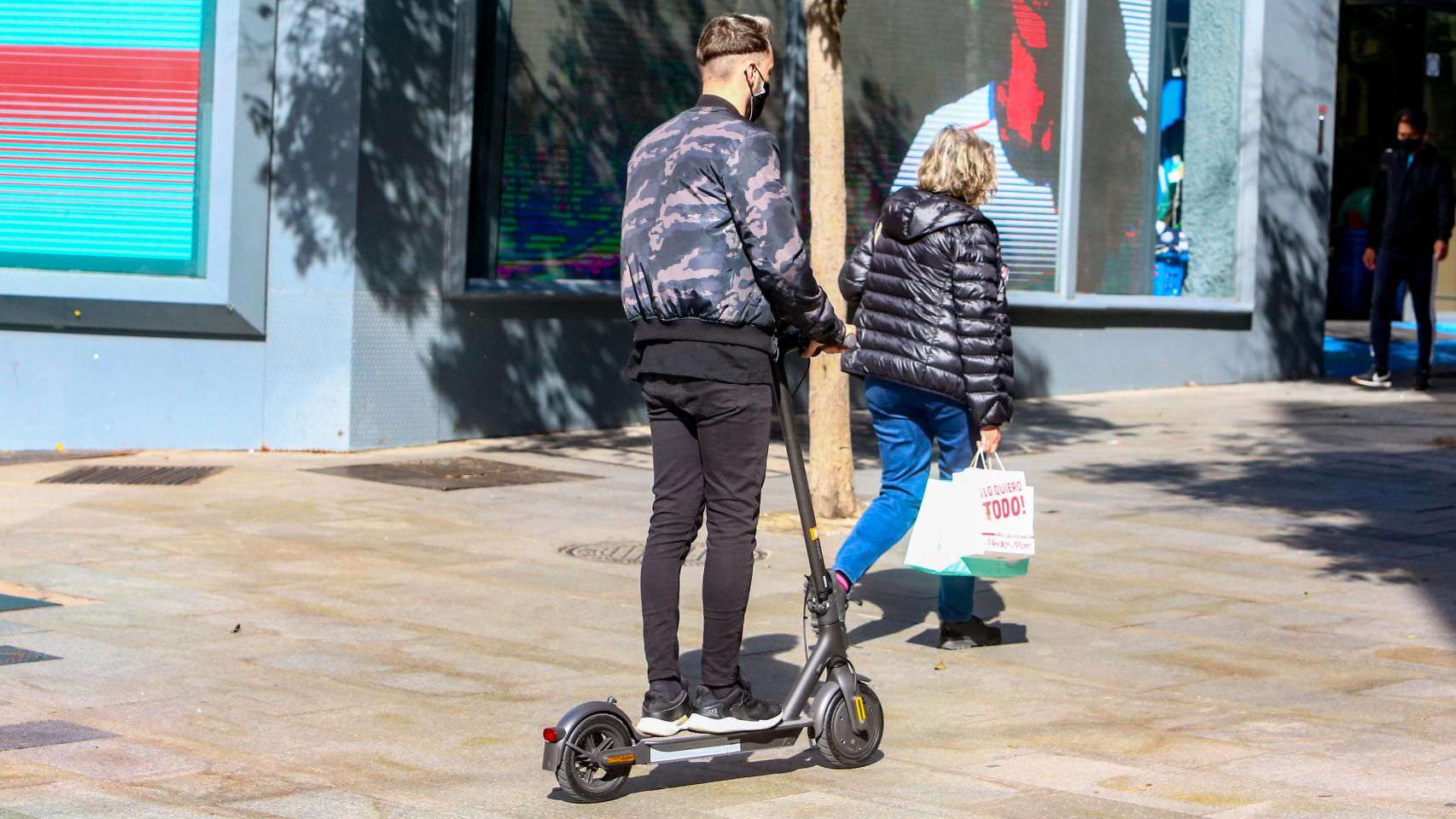 Patinete por una acera en Madrid.