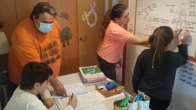 Román, y su mujer, María, dando clase a sus hijos en su casa de Las Torres de Cotillas (Murcia).