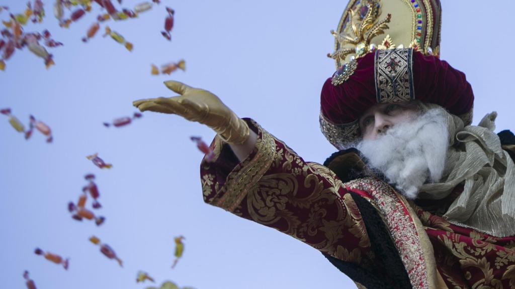 El rey Melchor lanza caramelos a los niños en una de las cabalgatas de 2020.