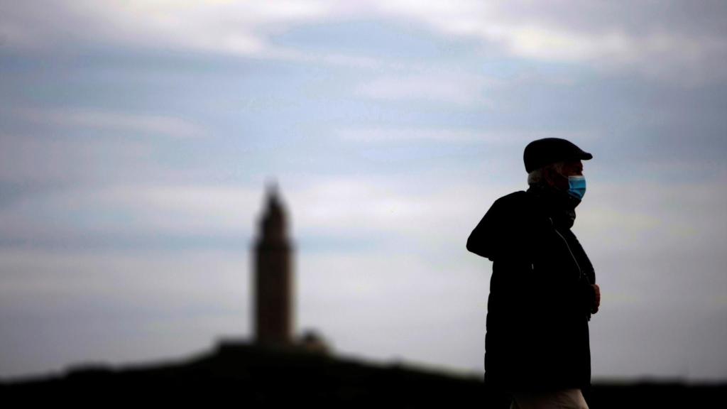 Un hombre camina por el paseo marítimo de Coruña.