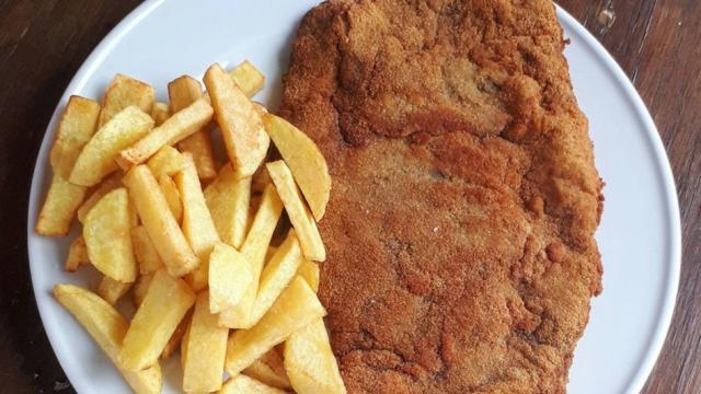 Un cachopo con patatas fritas.