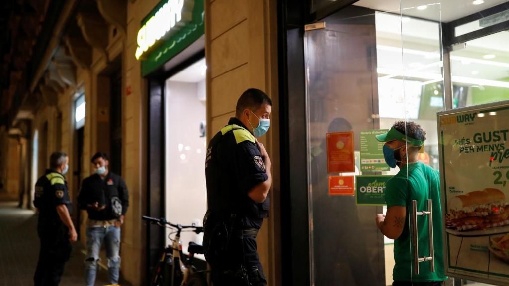 Los policías ordenan al establecimiento que debe de cerrar en orden al toque de queda.