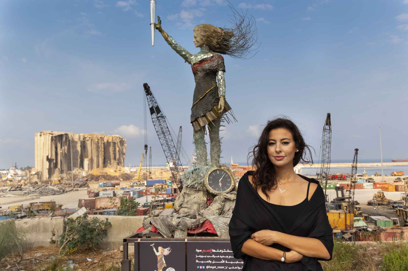 Hayat Nazer en el puerto de Beirut destruido por la explosión, junto a la escultura de la niña.