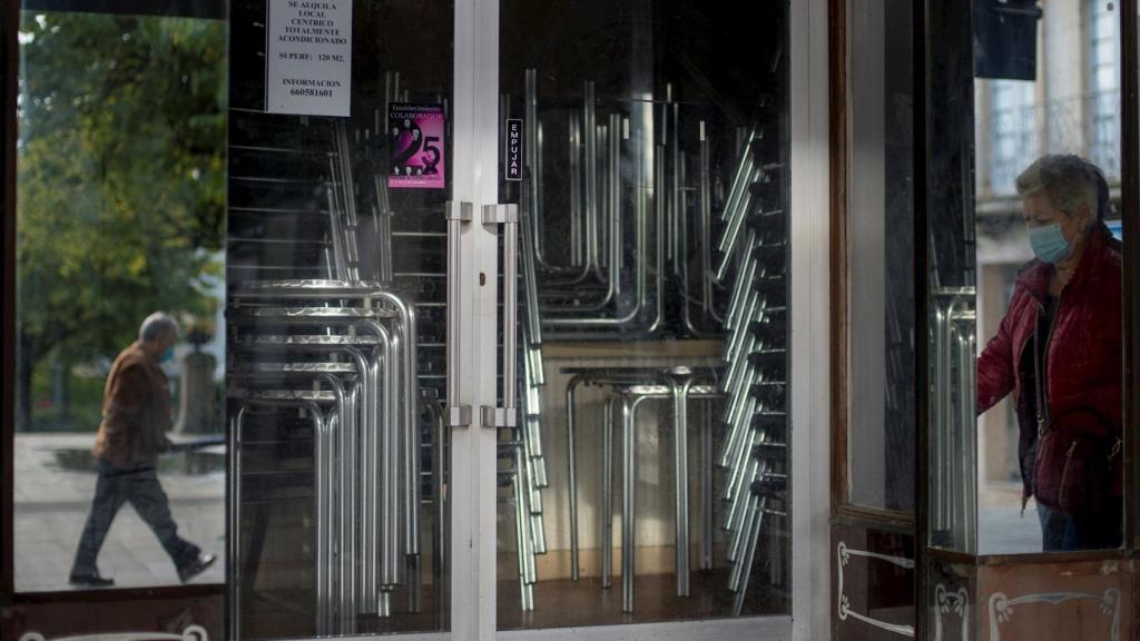 Un grupo de personas pasea frente a un restaurante cerrado, en O Carballiño (Orense)