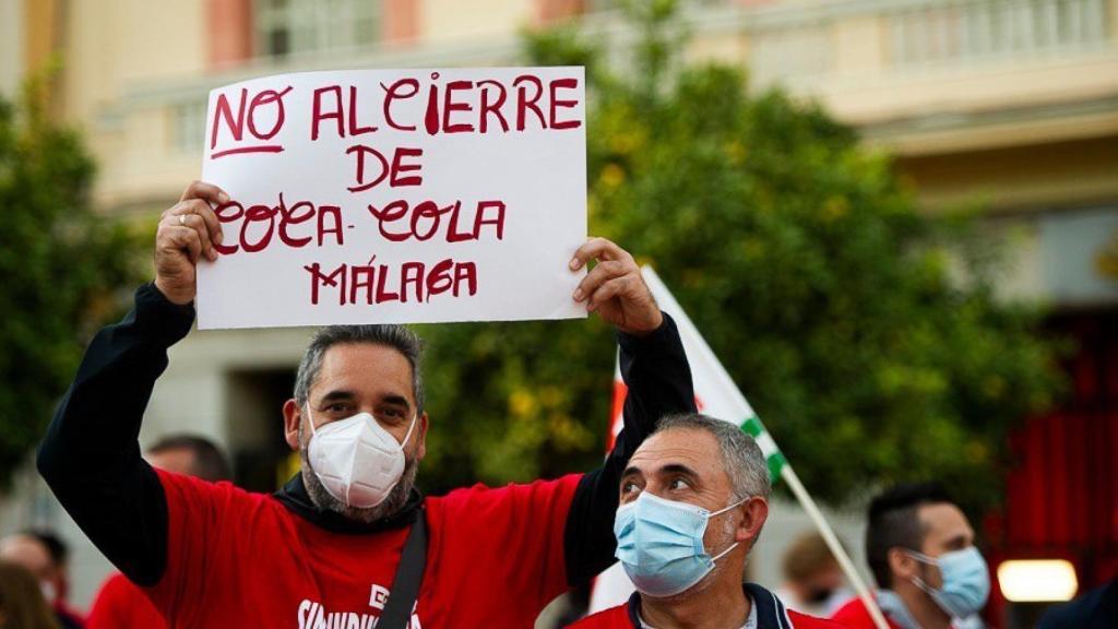 Un trabajador con una pancarta en la concentración contra el cierre de la planta de Coca-Cola en Málaga.