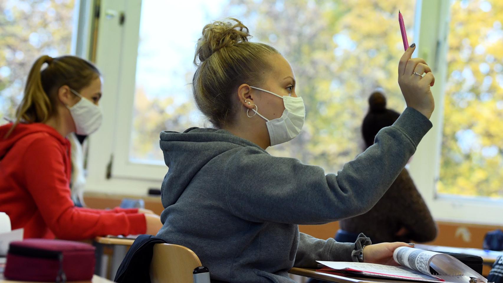 Una alumna alemana con mascarilla y dudas pregunta al profesor.