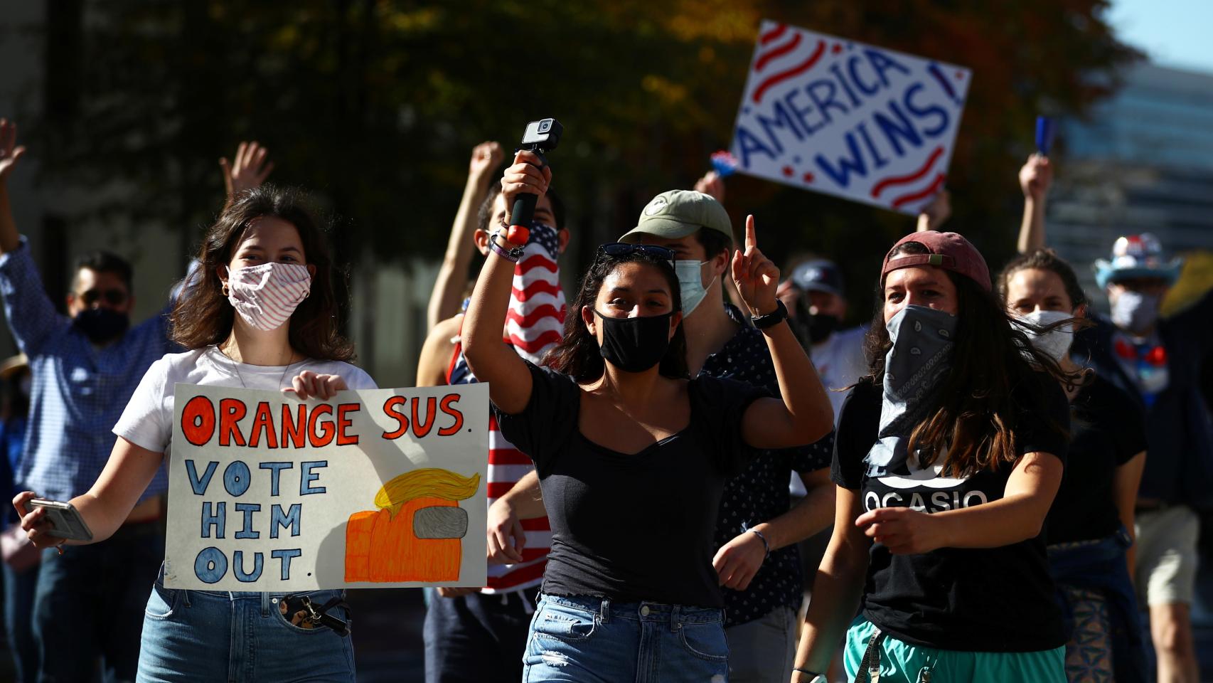 Tres chicas jóvenes con carteles contra Trump.