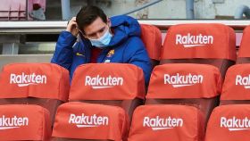 Leo Messi espera en el banquillo con mascarillas situado en la grada del Camp Nou durante la pandemia por la Covid-19
